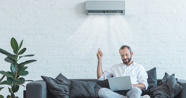 Homme calculant la consommation horaire de son climatiseur