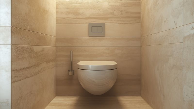 Photo d'un WC suspendu moderne avec sa plaque de commande pour illustrer le remplacement réussi du mécanisme de chasse d'eau