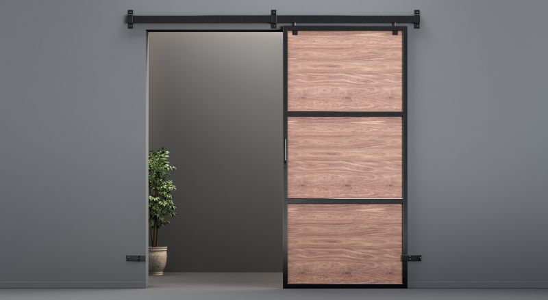 porte coulissante en bois finitions acier et rails en acier dans un interieur contemporain sombre et minimaliste