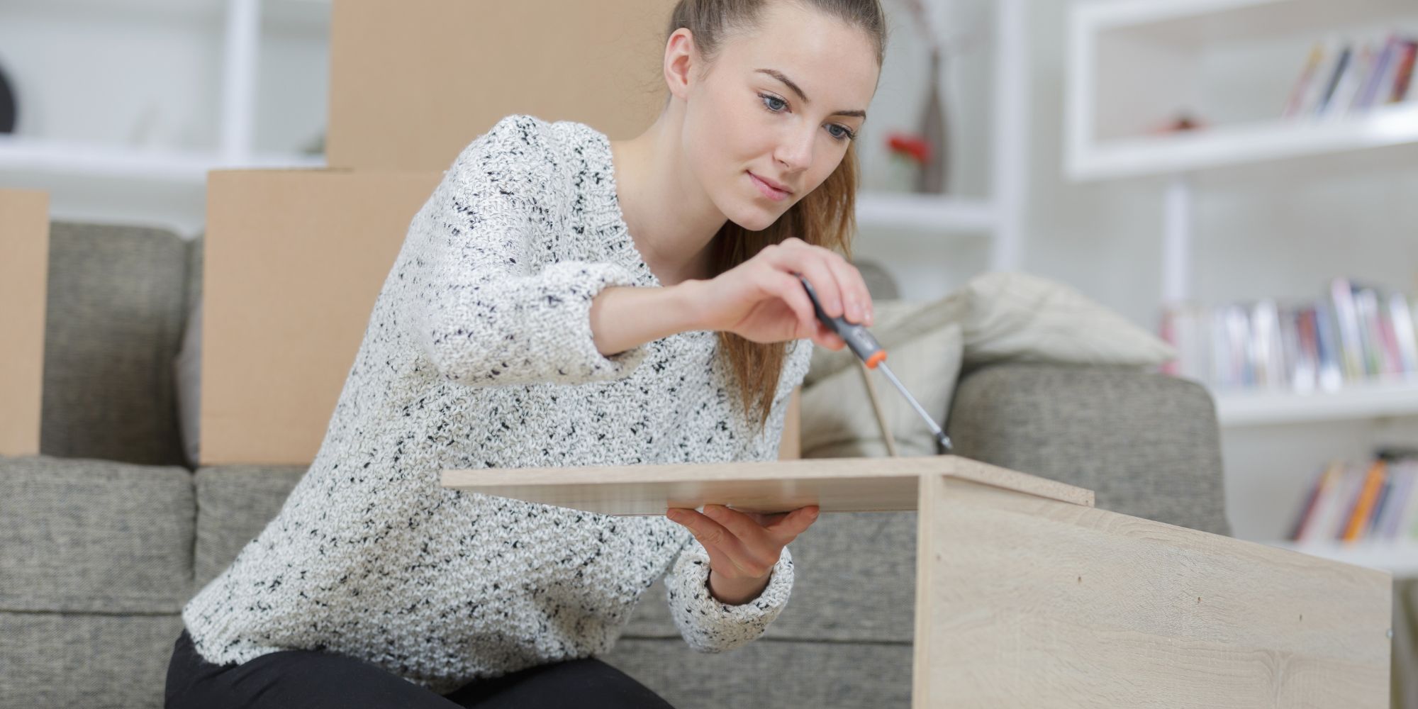 femme qui monte un meuble en kit seule