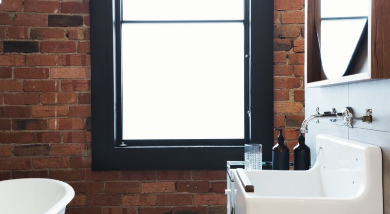 amenagement minimaliste et style industriel pour une petite salle de bain de 2m2 briques rouge encadrement de fenetres noires