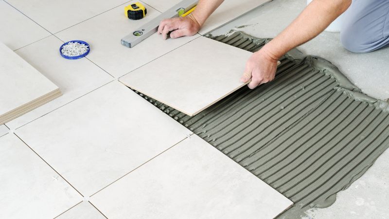 encollage de carreaux en ceramique par un carreleur professionnel