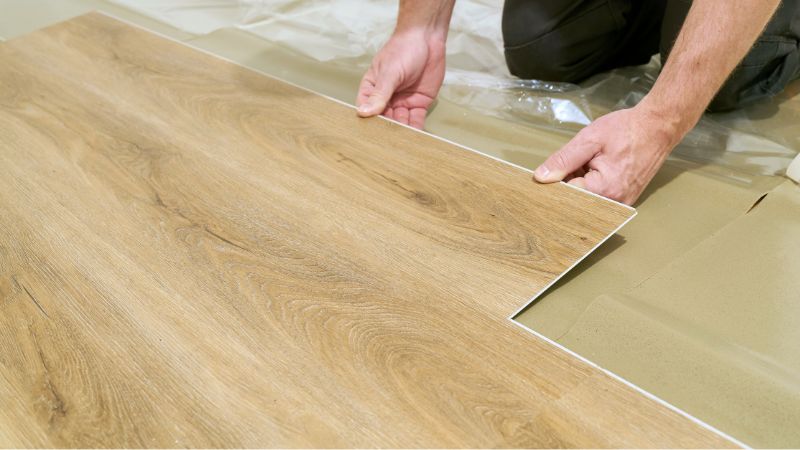 professionnel posant une lame de sol pvc clipsable