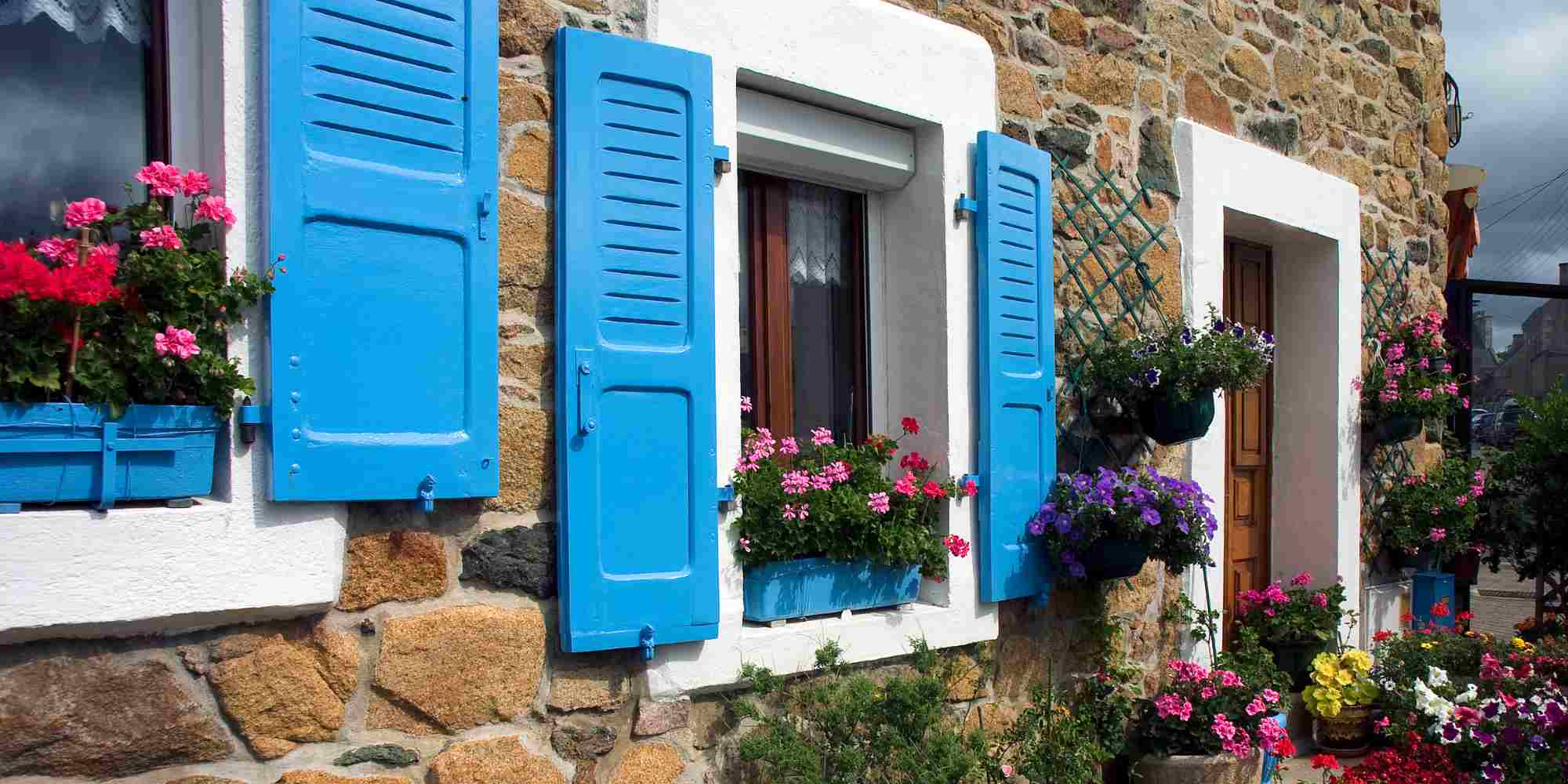 volets bleus sur une maison en pierre