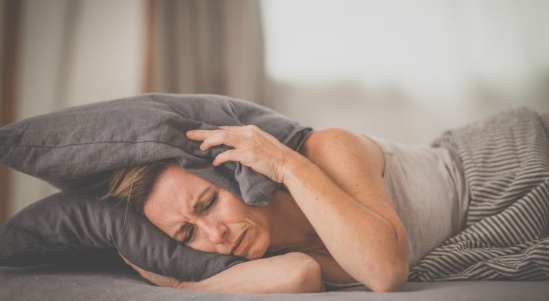 une personne visiblement contrariée alors qu'elle souhaite se reposer