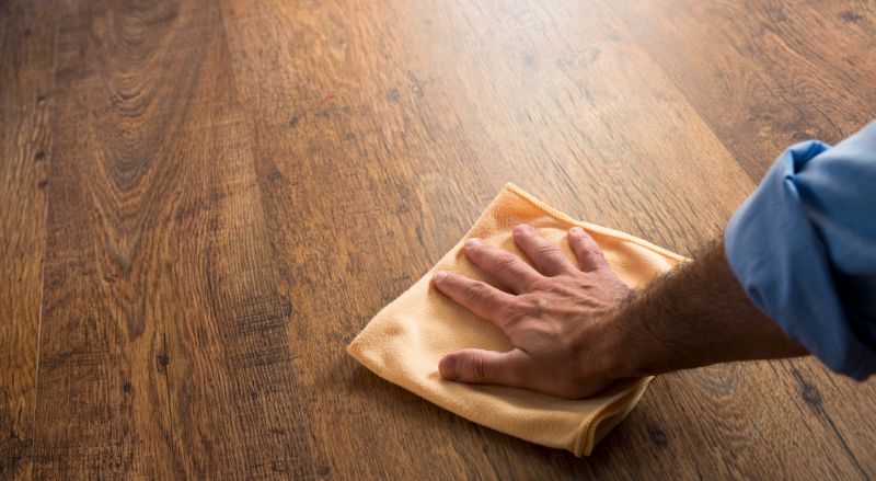 un homme passant un coup de chiffon sur son parquet