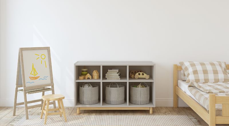 chambre pour enfant minimaliste aux tons gris avec un meuble de rangement dans lequel il y a trois paniers de rangement de taille identique