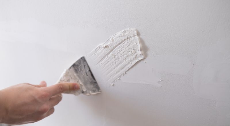 reparer les murs avec du mastic et une spatule