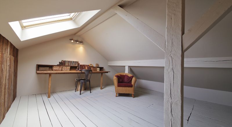 combles amenages avec poutres en bois peintes en blanc