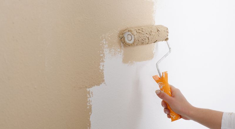 gros plein sur la peinture au rouleau d un mur de blanc a beige