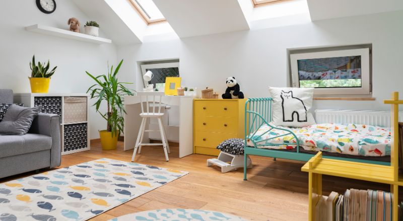 chambre pour enfant moderne et pleine de couleurs avec une commode jouxtant le bureau pour ranger les fournitures scolaires