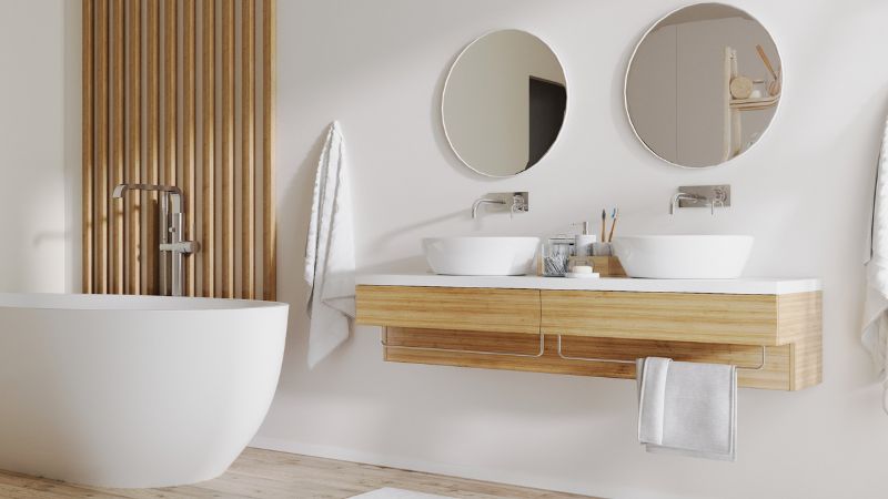 salle de bain avec ses meubles en bois clair et ses miroirs ronds