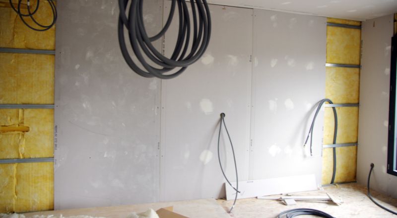 pose de bandes de placo sur rails metalliques en cours 