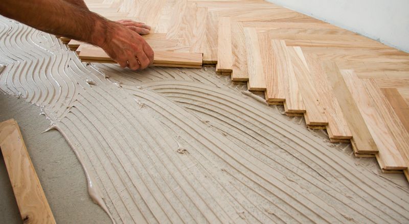 pose collée pour un parquet à chevrons