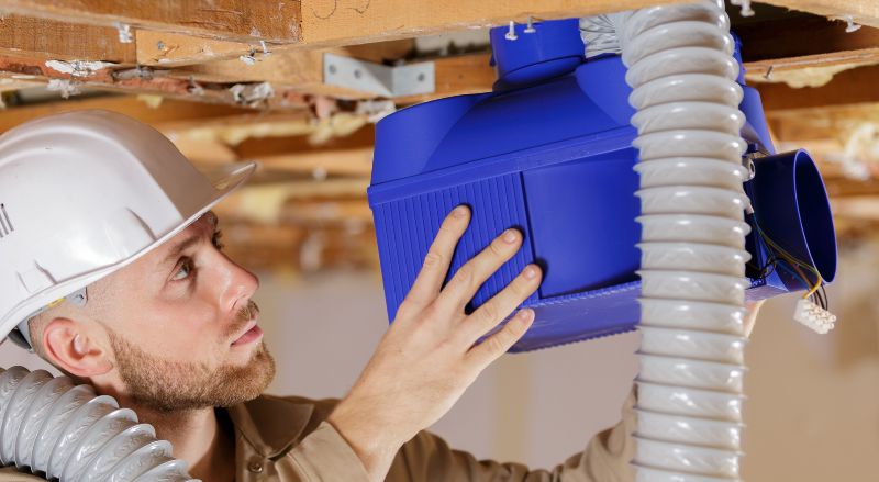 professionnel en train d installer une vmc dans des combles