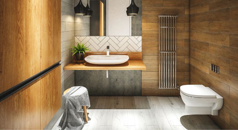 seche serviette en inox avec une forme design dans une salle bain avec carrelage effet bois credence blanche et luminaire en metal noir 